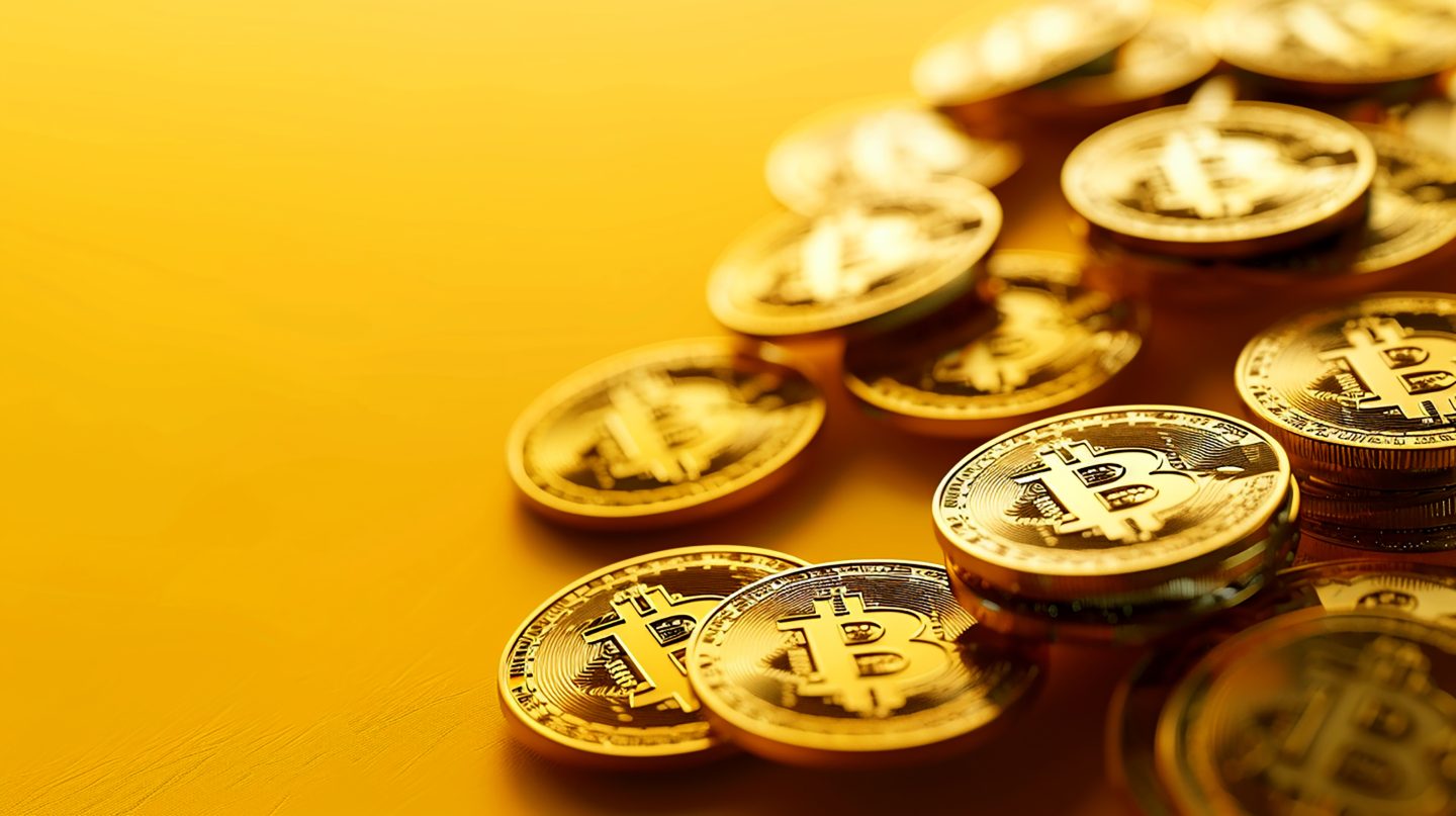 Gold Bitcoin Cryptocurrency Coins on a Yellow Background